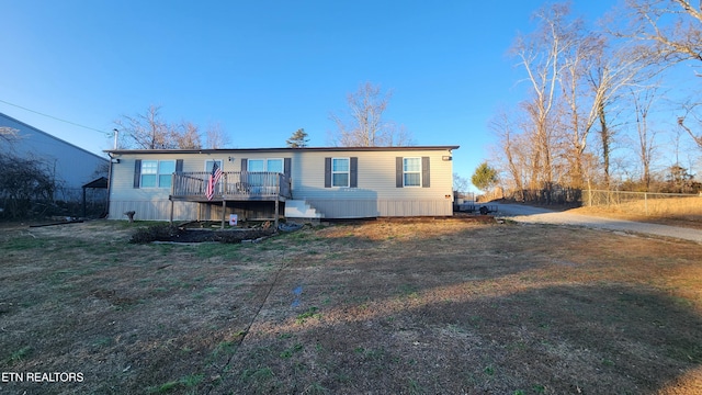 manufactured / mobile home featuring a front yard and a wooden deck