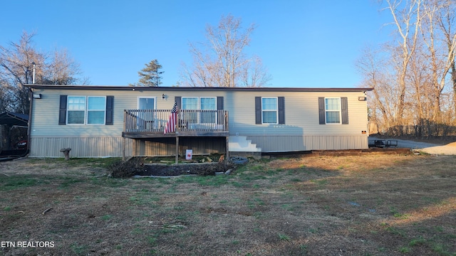 view of front of property featuring a front lawn and a wooden deck