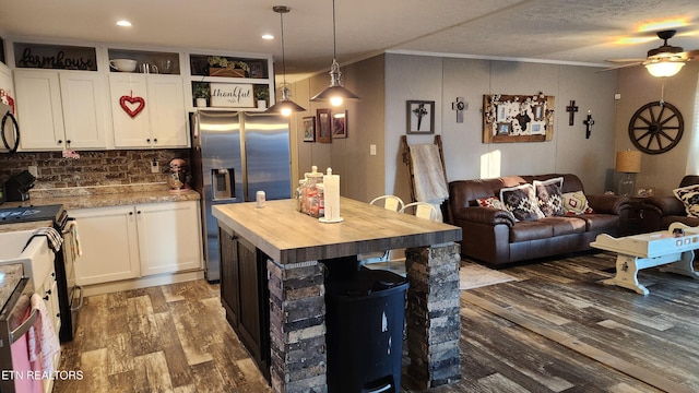 kitchen with stainless steel fridge with ice dispenser, stove, a kitchen island, pendant lighting, and white cabinets