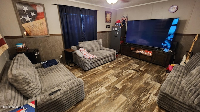 living room featuring ceiling fan, ornamental molding, and hardwood / wood-style flooring