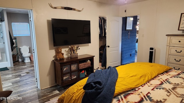 bedroom with dark wood-type flooring and ensuite bath