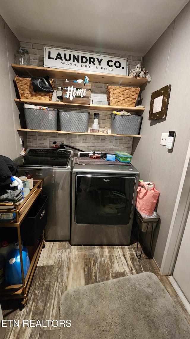 washroom with hardwood / wood-style flooring and washer and dryer