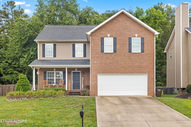 view of front facade featuring a garage, a front yard, and covered porch