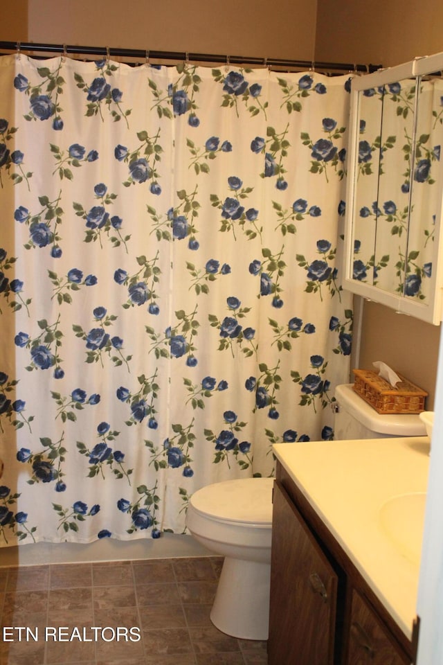 bathroom with toilet, a shower with shower curtain, and vanity