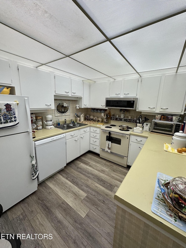 kitchen featuring backsplash, extractor fan, sink, white appliances, and white cabinets