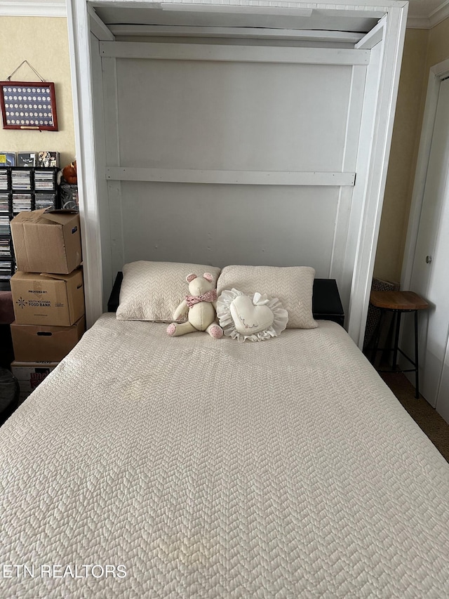 bedroom with a closet and crown molding