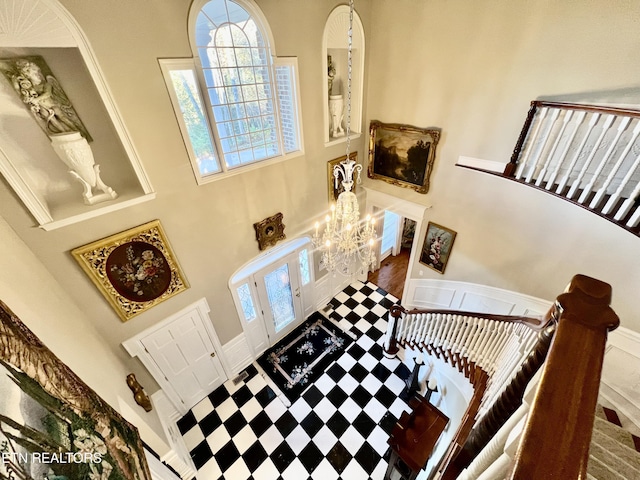 foyer featuring a high ceiling, a chandelier, and french doors