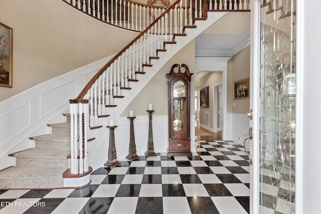 entrance foyer featuring a towering ceiling and ornamental molding