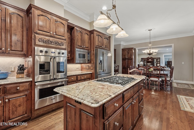 kitchen with stainless steel appliances, hanging light fixtures, a center island, and dark wood-type flooring