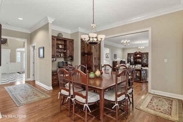 dining room with an inviting chandelier, crown molding, and hardwood / wood-style floors