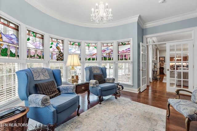 living area featuring a notable chandelier, crown molding, dark hardwood / wood-style floors, and french doors