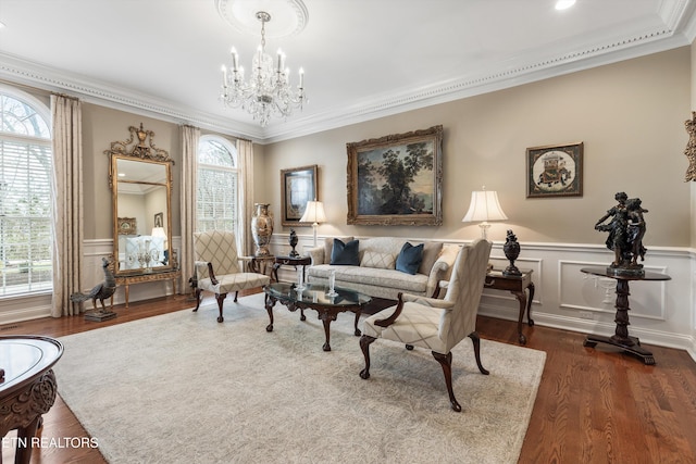 sitting room with crown molding, dark wood-type flooring, and an inviting chandelier