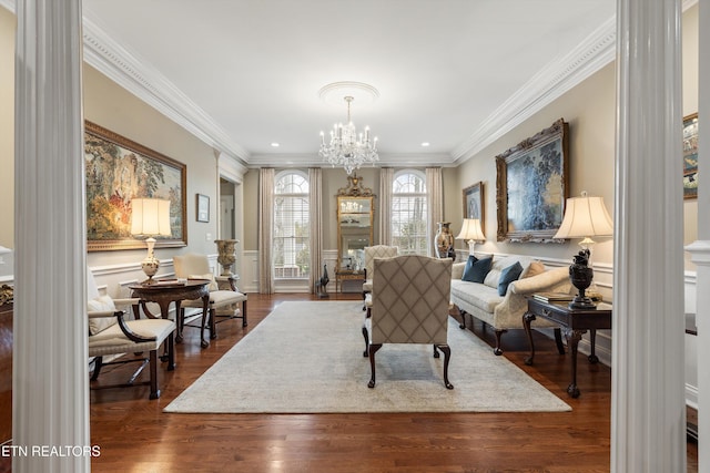 living area featuring crown molding, dark hardwood / wood-style floors, and an inviting chandelier