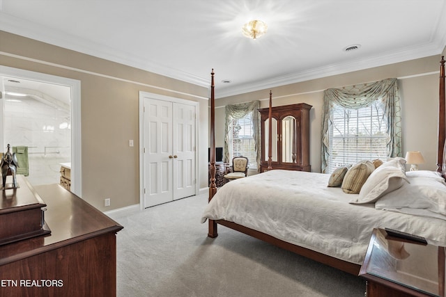 carpeted bedroom with crown molding, ensuite bath, and a closet