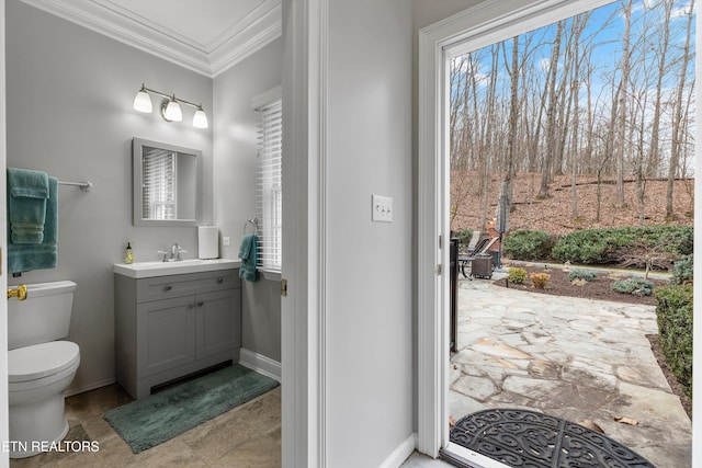 bathroom featuring ornamental molding, plenty of natural light, vanity, and toilet