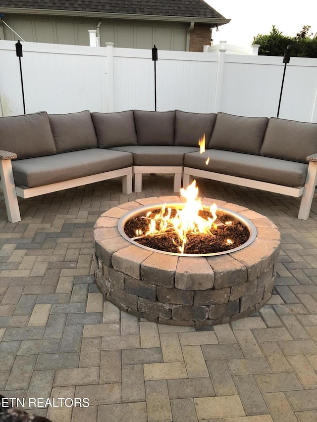 view of patio with an outdoor living space with a fire pit