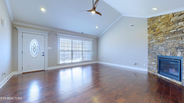 unfurnished living room with vaulted ceiling, a stone fireplace, crown molding, and dark hardwood / wood-style floors