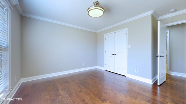 unfurnished bedroom with dark wood-type flooring, a closet, and ornamental molding