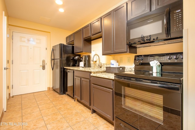 kitchen with light tile patterned floors, dark brown cabinets, light stone counters, and black appliances