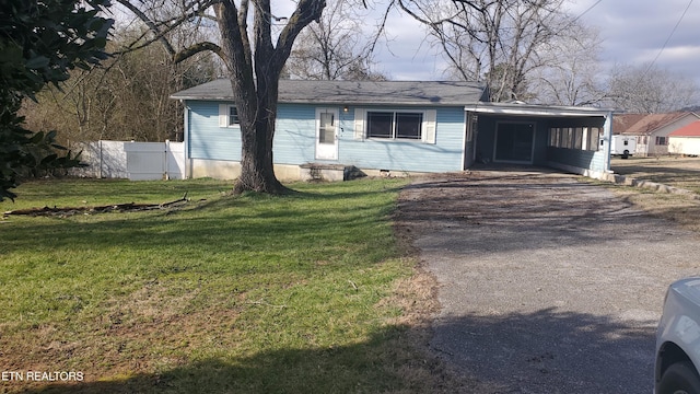 view of front of property featuring a front lawn and a carport