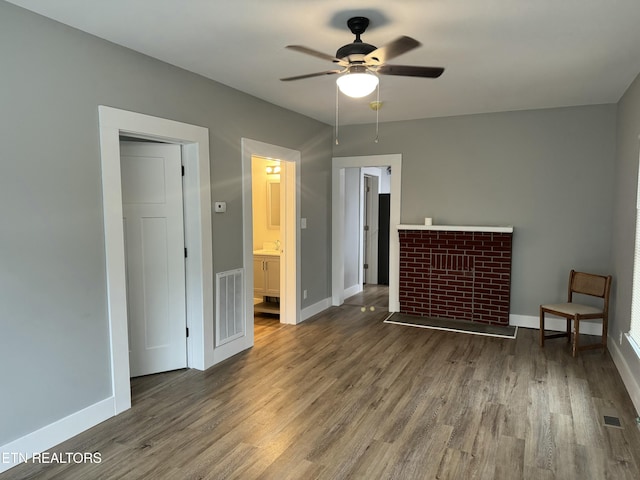 unfurnished bedroom featuring ceiling fan, a closet, dark hardwood / wood-style floors, and connected bathroom