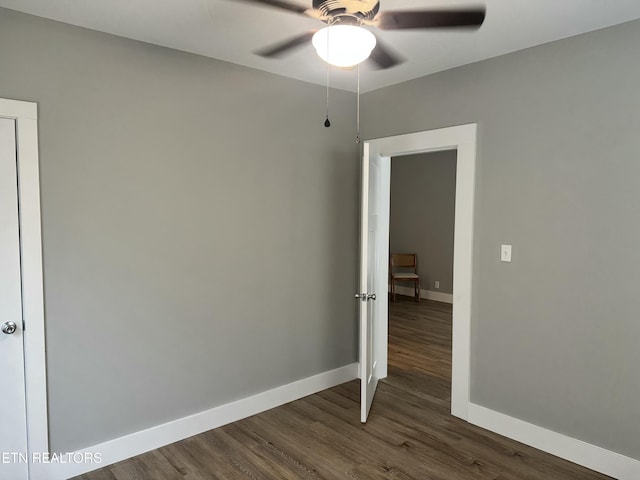 empty room featuring ceiling fan and dark hardwood / wood-style flooring