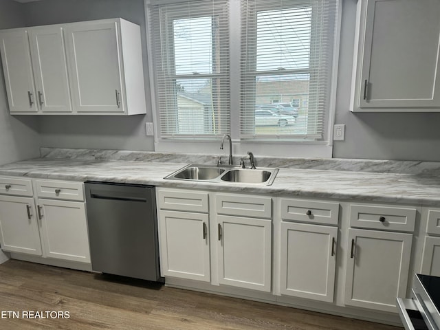 kitchen with sink, white cabinetry, black dishwasher, and light wood-type flooring