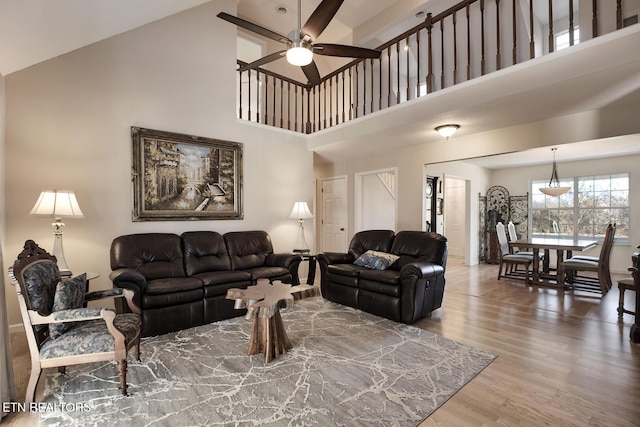 living room with high vaulted ceiling, hardwood / wood-style floors, and ceiling fan