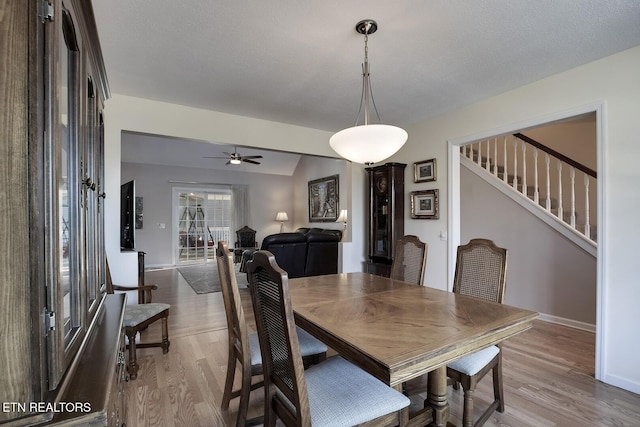 dining room featuring light hardwood / wood-style floors, ceiling fan, and vaulted ceiling