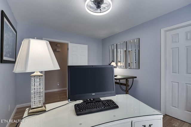 office with wood-type flooring and a textured ceiling