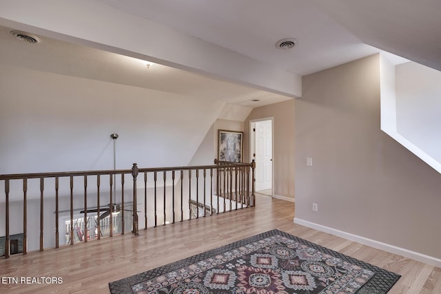 hall with vaulted ceiling and light wood-type flooring