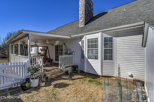 back of house with ceiling fan, a lawn, and a porch