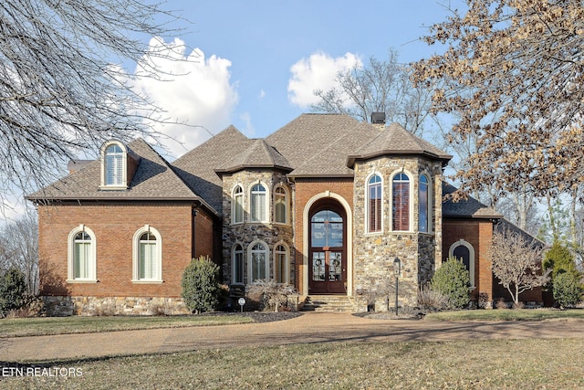 french country style house featuring a front yard and french doors