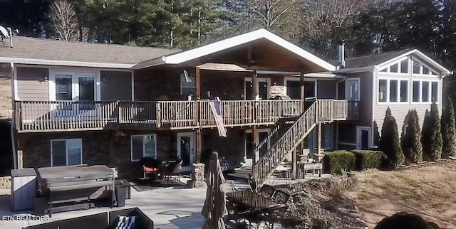 back of house with a hot tub and a patio area