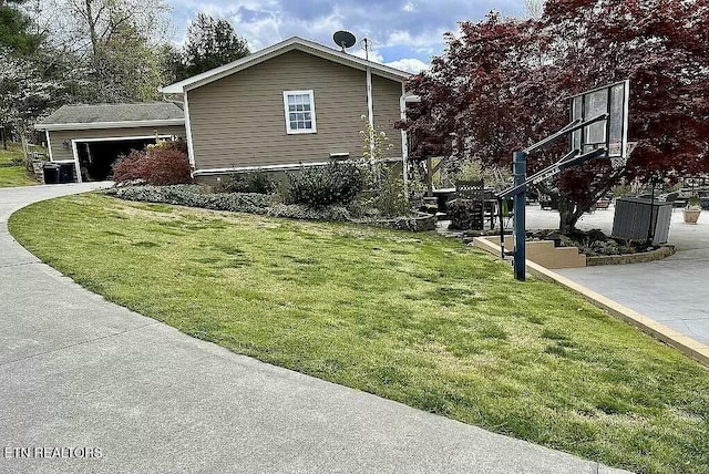 view of side of property with a garage and a lawn