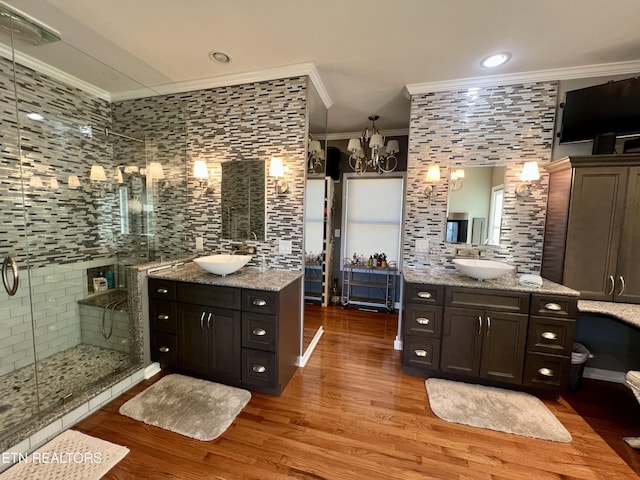 bathroom with walk in shower, ornamental molding, wood-type flooring, and vanity