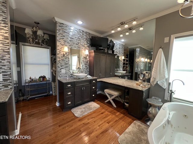 bathroom featuring crown molding, a tub to relax in, wood-type flooring, and vanity