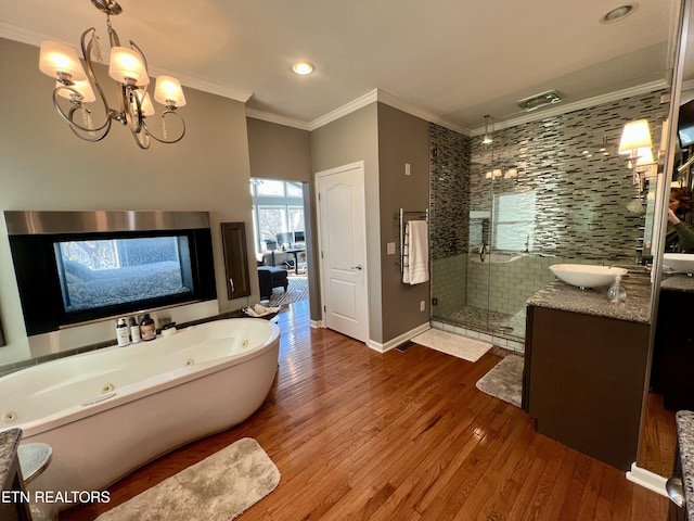 bathroom featuring wood-type flooring, ornamental molding, vanity, independent shower and bath, and a notable chandelier