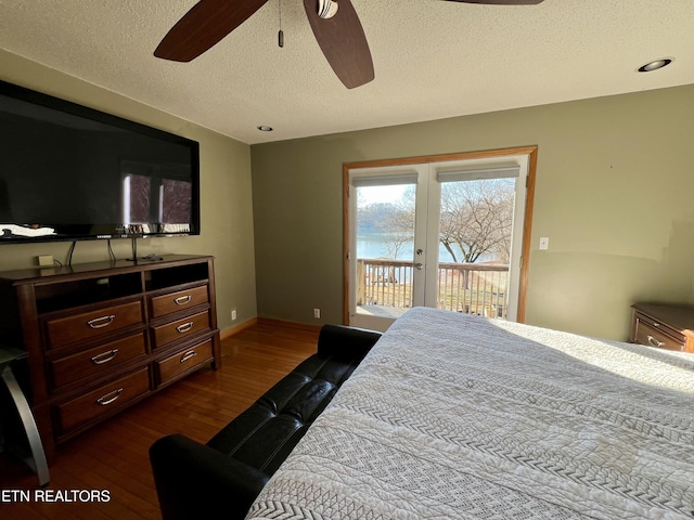 bedroom featuring ceiling fan, access to exterior, hardwood / wood-style floors, a textured ceiling, and french doors