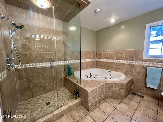 bathroom with tile patterned floors, separate shower and tub, and tile walls