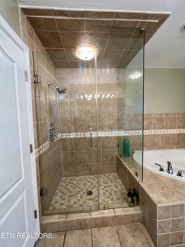 bathroom with tile patterned floors and plus walk in shower