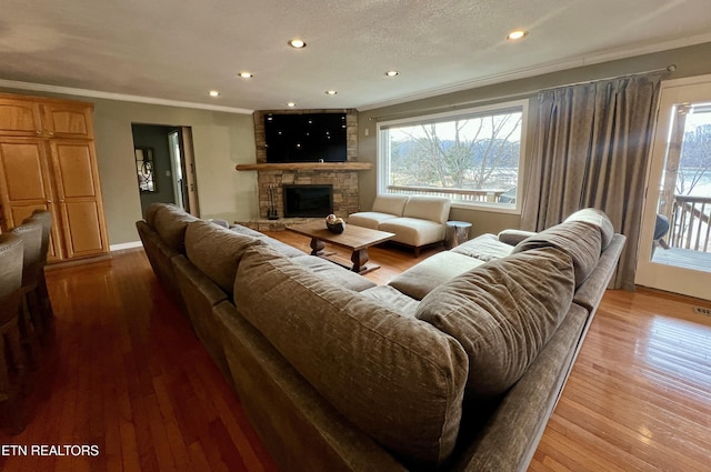 living room featuring crown molding, a fireplace, and light wood-type flooring