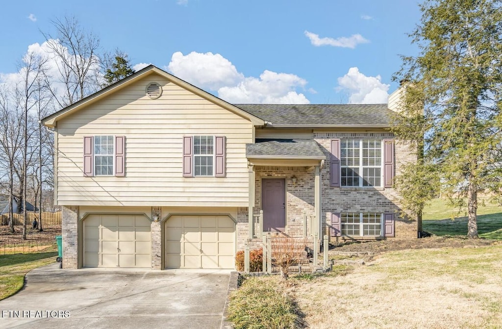 bi-level home with a garage and a front yard