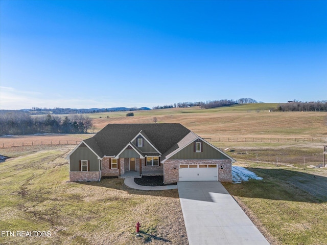 craftsman-style house featuring a garage, a front yard, and a rural view