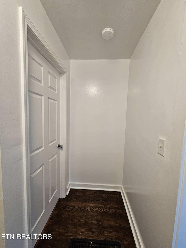 hallway with dark hardwood / wood-style flooring