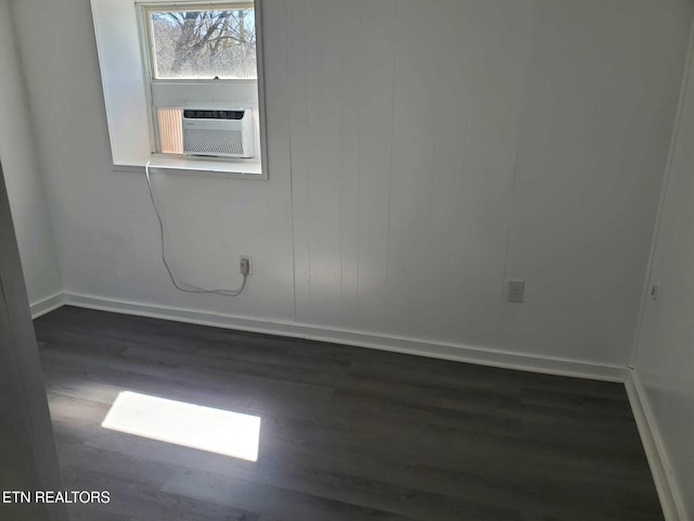 unfurnished room featuring cooling unit and dark hardwood / wood-style flooring