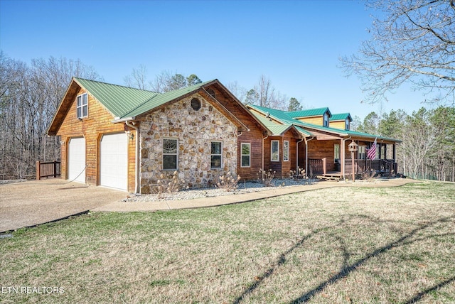 view of front of home featuring a porch, a garage, and a front yard