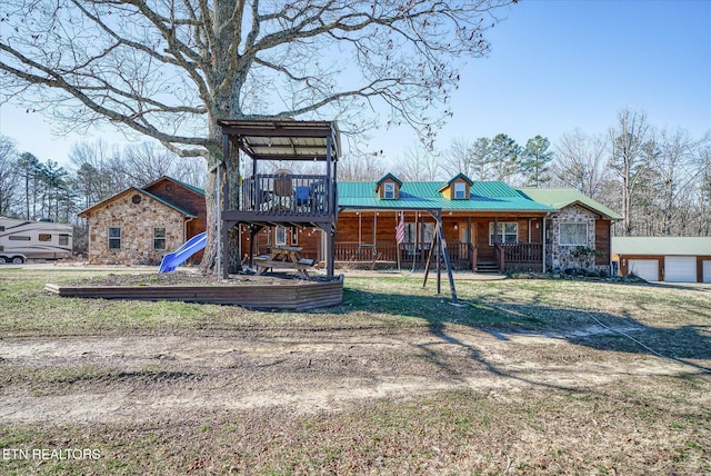 rear view of property featuring a porch and a playground