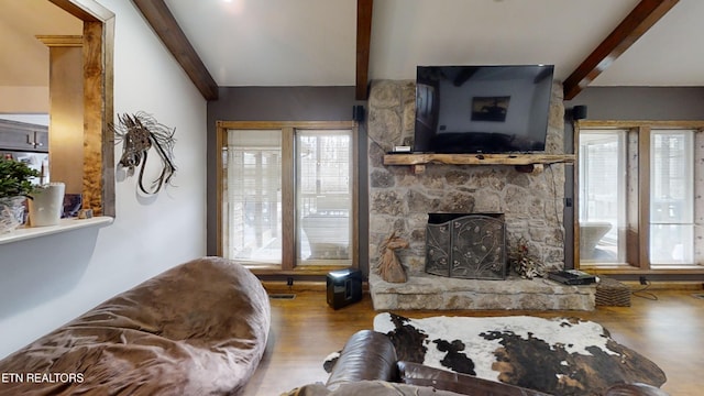 living room with hardwood / wood-style flooring, a fireplace, and beamed ceiling