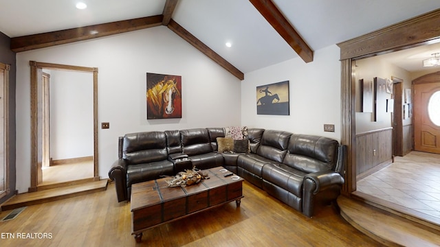 living room with vaulted ceiling with beams and light hardwood / wood-style floors